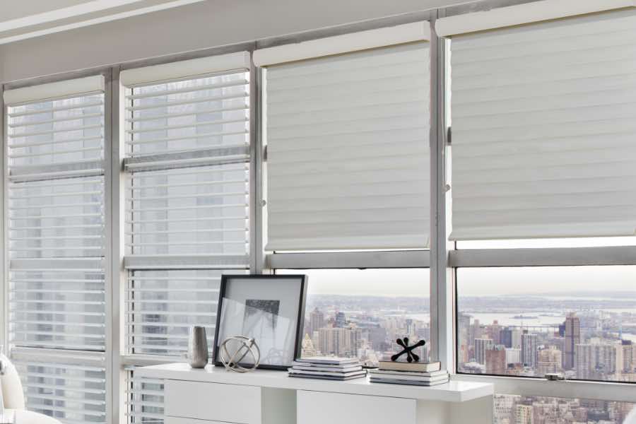 White sheer window shades on windows in a high rise penthouse bedroom